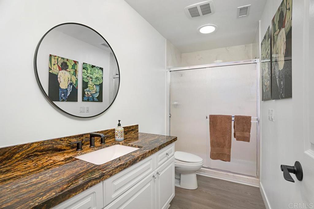 1237 Granada Way San Marcos, CA 92078 - Photo 20 of 27 a bathroom with a granite countertop sink a mirror and a toilet