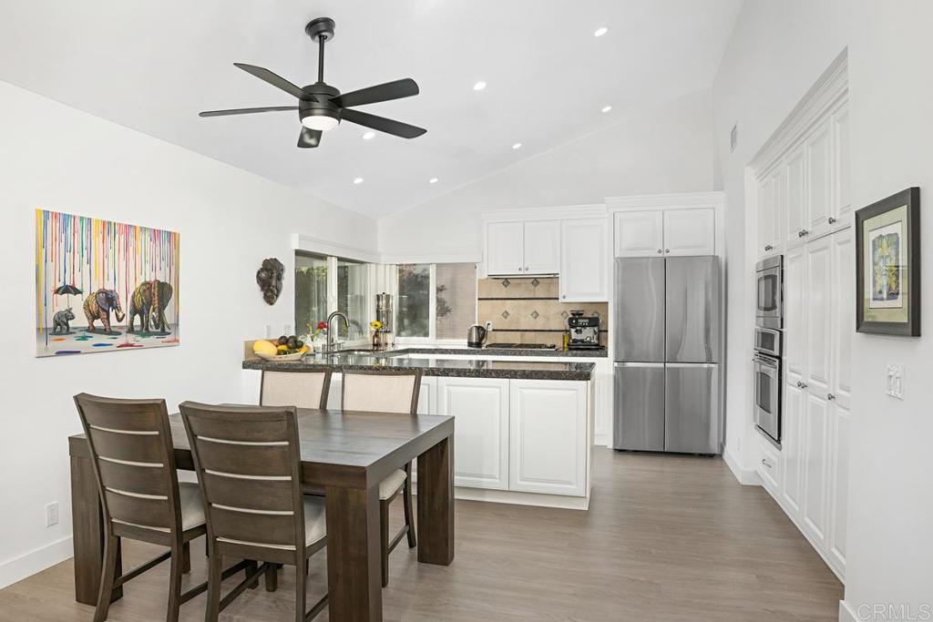 1237 Granada Way San Marcos, CA 92078 - Photo 7 of 27 a kitchen with stainless steel appliances a table chairs and a refrigerator