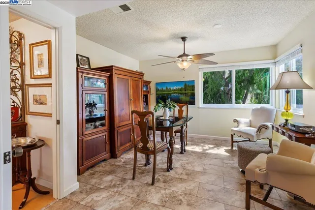 a dining room with furniture a large window and a chandelier