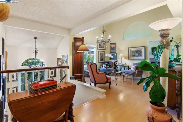 a living room with furniture a chandelier and a dining table