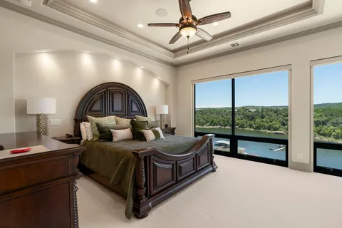 a spacious bedroom with a bed and a large window with the outer view