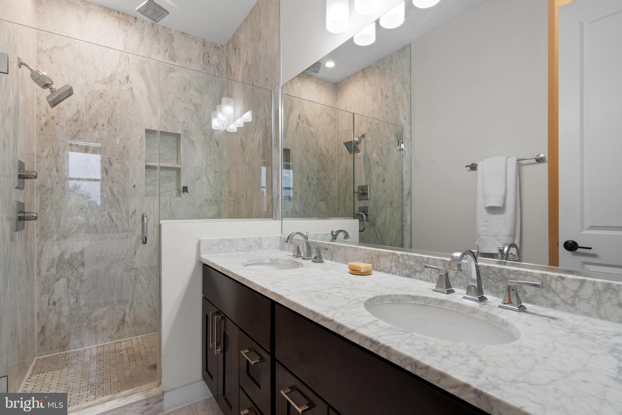 913 12th Street Northeast, Unit 4 Washington, DC 20002 - Photo 16 of 33 a bathroom with a granite countertop sink a mirror and a shower