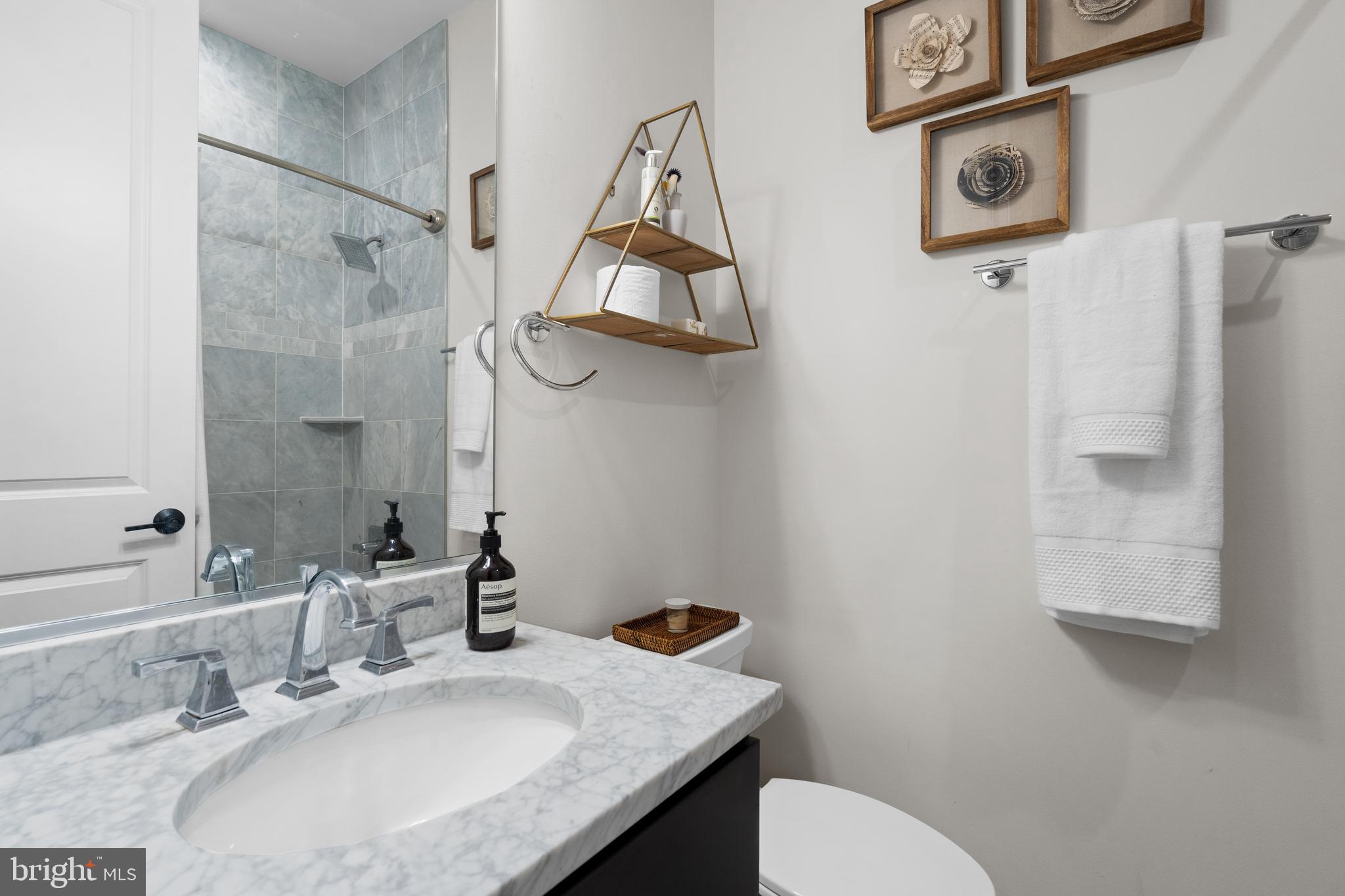 913 12th Street Northeast, Unit 4 Washington, DC 20002 - Photo 20 of 33 a bathroom with a granite countertop sink a toilet and shower