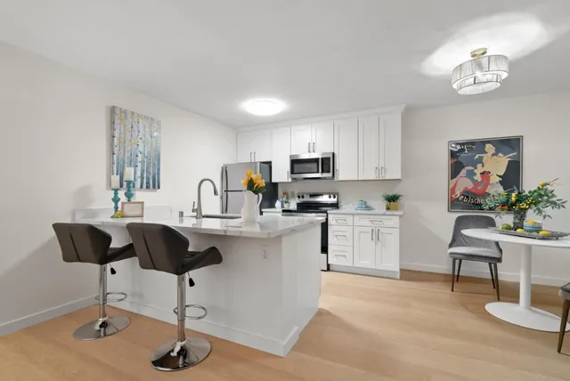 a living room with furniture and view of kitchen