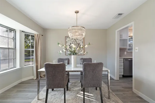a dining room with furniture a chandelier and wooden floor