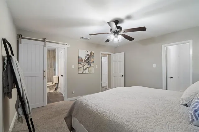 a bedroom with a large bed and a chandelier
