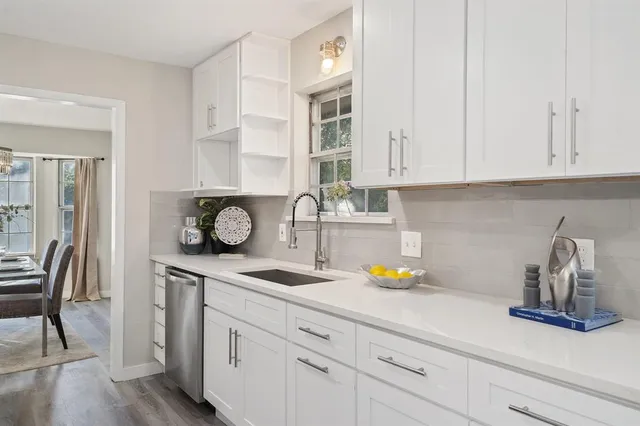 a kitchen with a sink cabinets and wooden floor