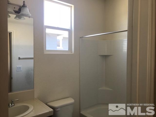 2185 Stanhope Lane Reno, NV 89502 - Photo 9 of 12 a bathroom with a granite countertop toilet a sink and shower