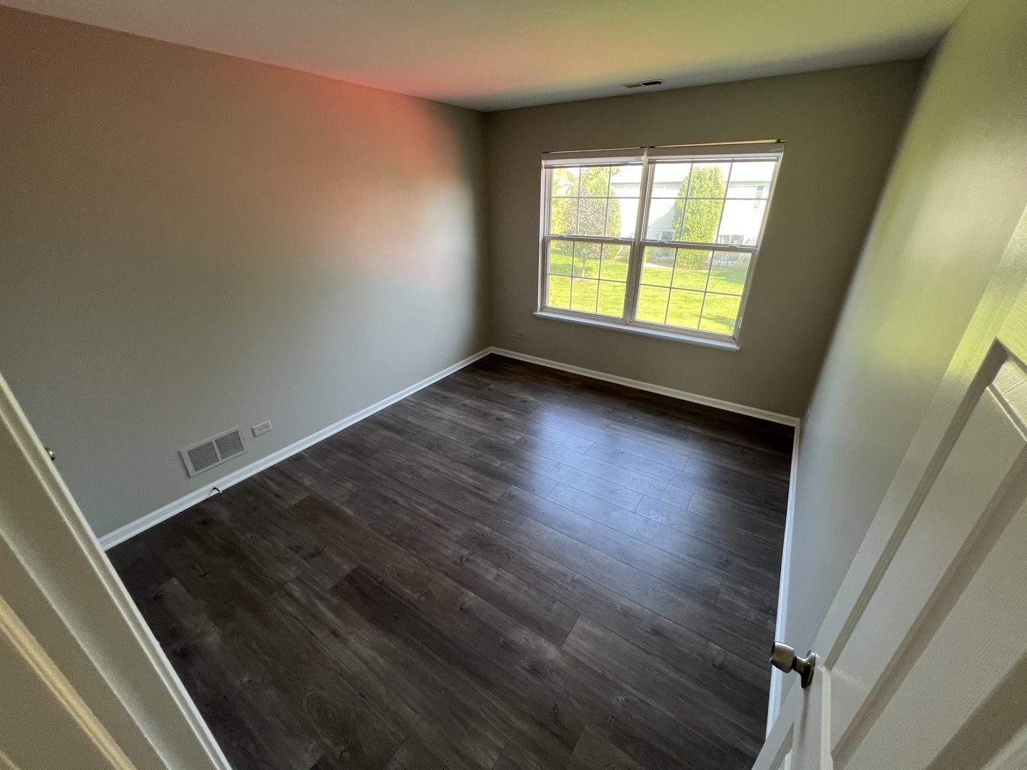 3044 Troon Drive Montgomery, IL 60538 - Photo 4 of 20 a view of an empty room with wooden floor and a window