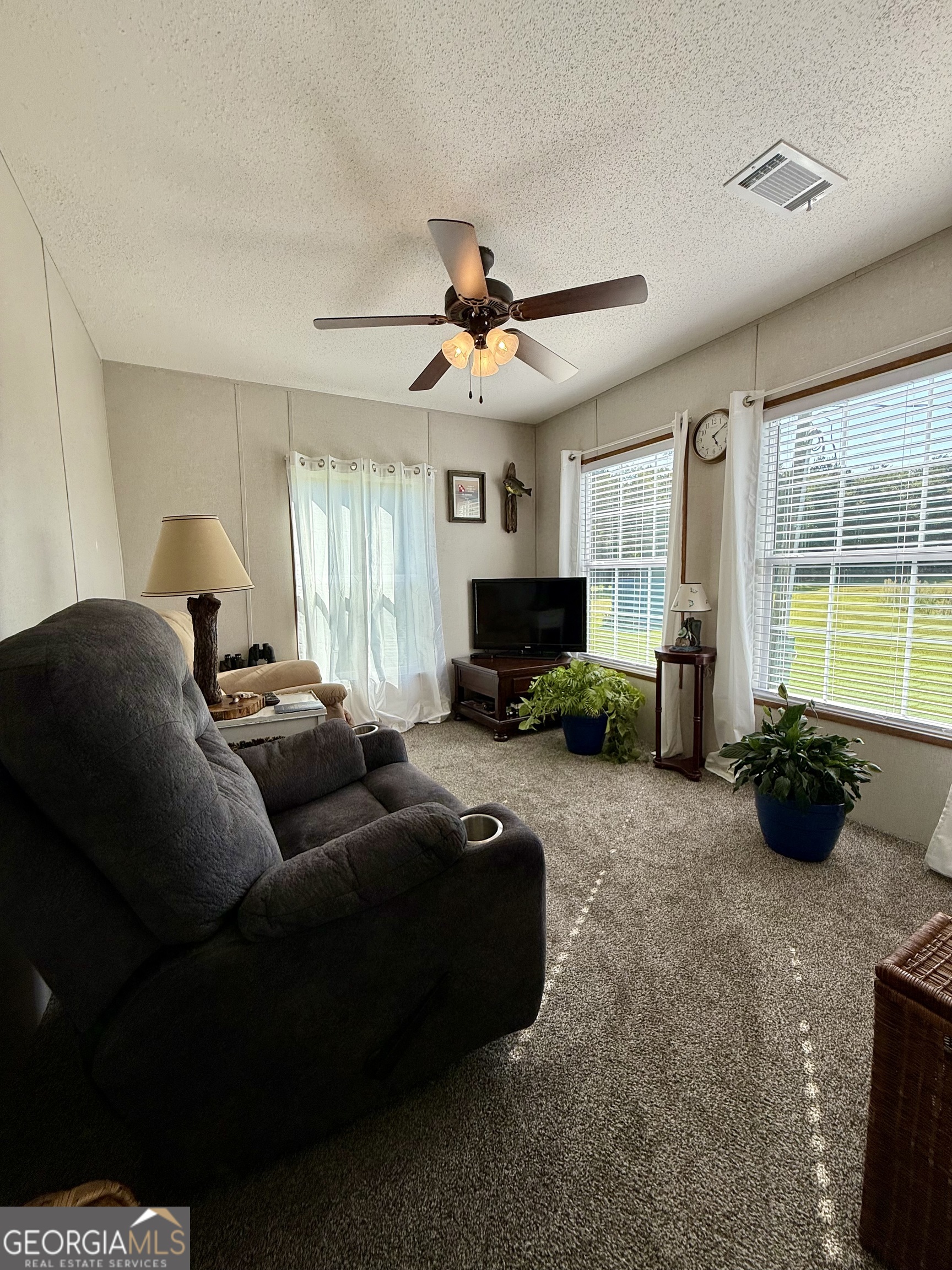1430 Old Poor Robin Road Sylvania, GA 30467 - Photo 16 of 30 a living room with furniture a large window and flat screen tv