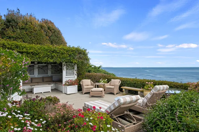a view of a patio with couches table and chairs and potted plants