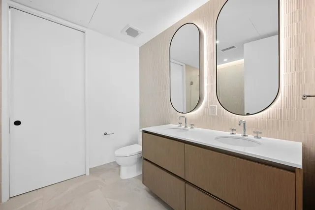 a bathroom with a granite countertop sink a toilet and a mirror