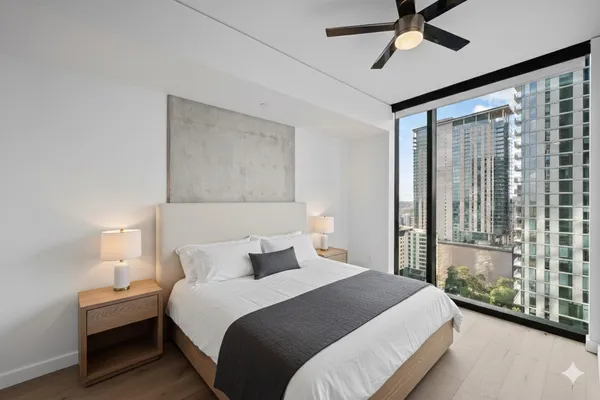 a bedroom with a large bed and a chandelier fan