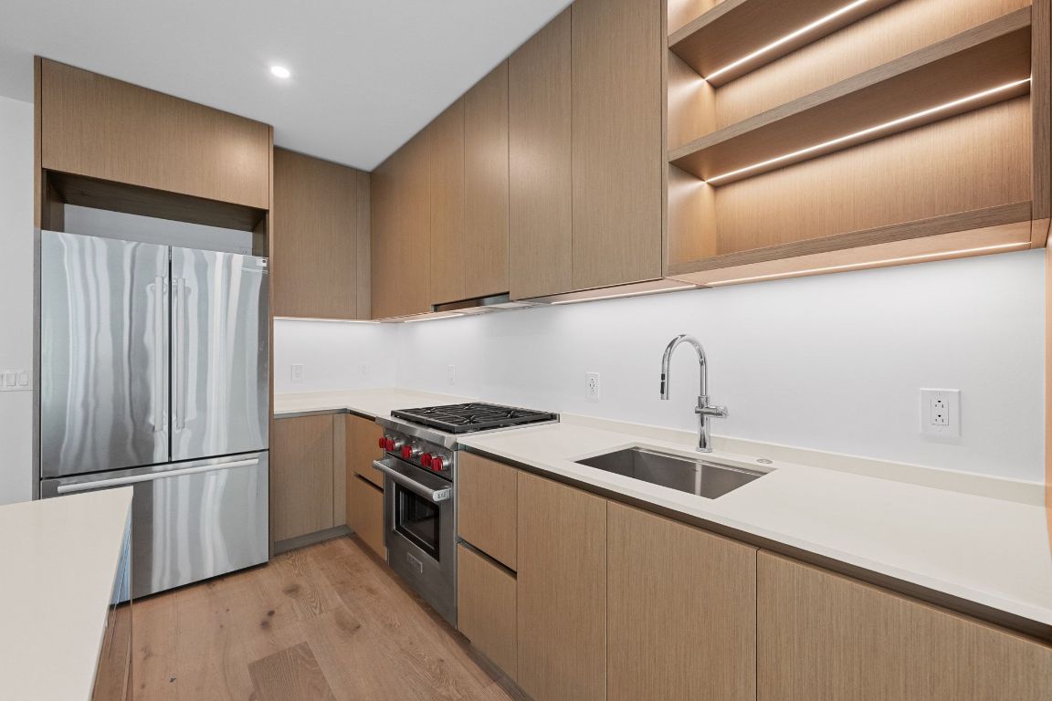 610 Davis Street, Unit 2103 Austin, TX 78701 - Photo 9 of 32 a kitchen with stainless steel appliances granite countertop a sink a stove and a refrigerator