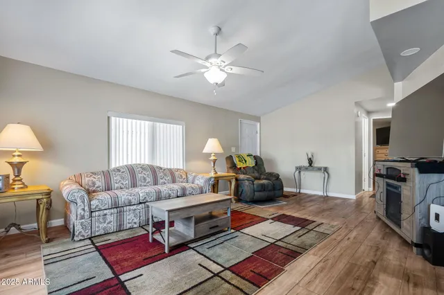 a living room with furniture a flat screen tv and a window