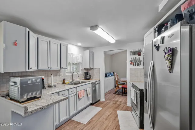 a kitchen with stainless steel appliances granite countertop a refrigerator sink and cabinets