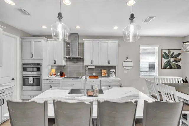 a kitchen with stainless steel appliances kitchen island granite countertop a sink a stove and cabinets