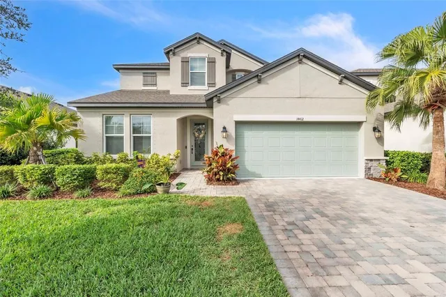 a front view of a house with a yard and potted plants