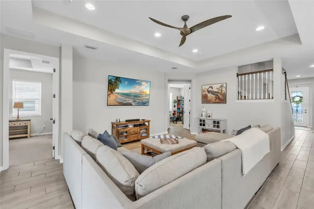 a large white kitchen with a stove a sink dishwasher and a refrigerator with wooden floor