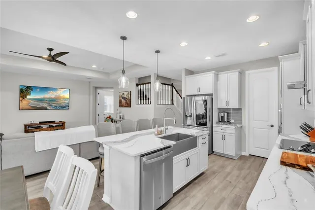 a view of a dining room and livingroom with furniture wooden floor a chandelier