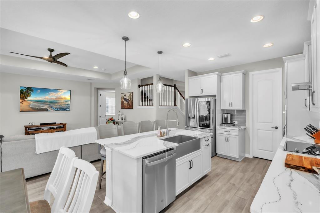 14412 20th Street East Parrish, FL 34219 - Photo 8 of 57 a large white kitchen with a stove a sink dishwasher and a refrigerator with wooden floor