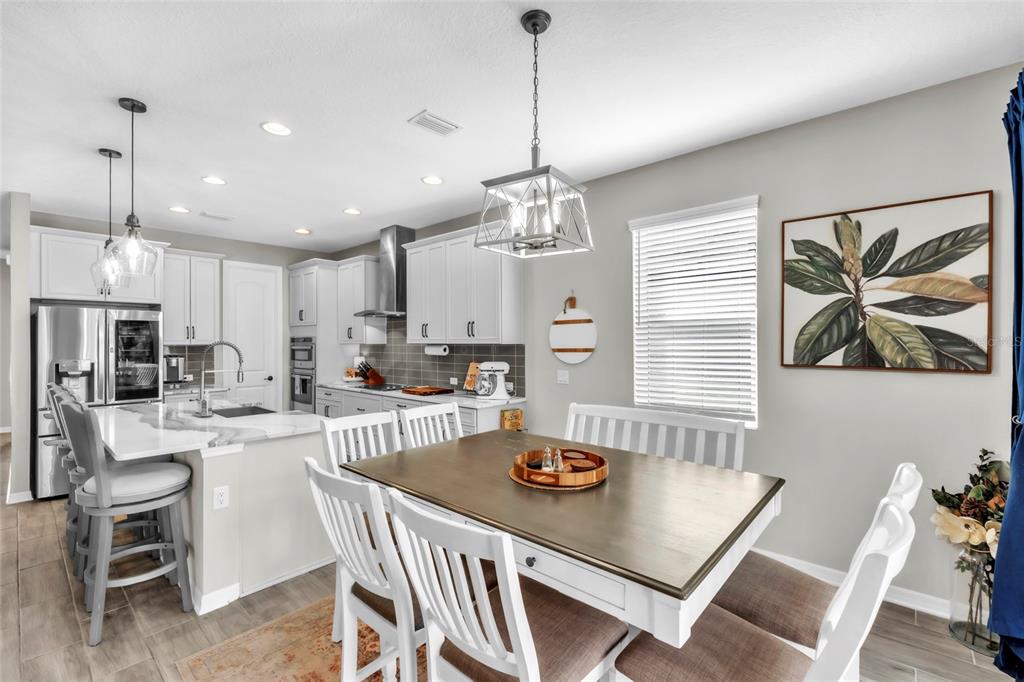 14412 20th Street East Parrish, FL 34219 - Photo 10 of 57 a kitchen with a dining table cabinets stainless steel appliances and a dining table