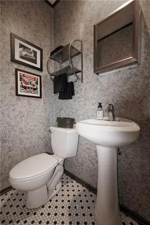 a bathroom with a toilet sink and mirror