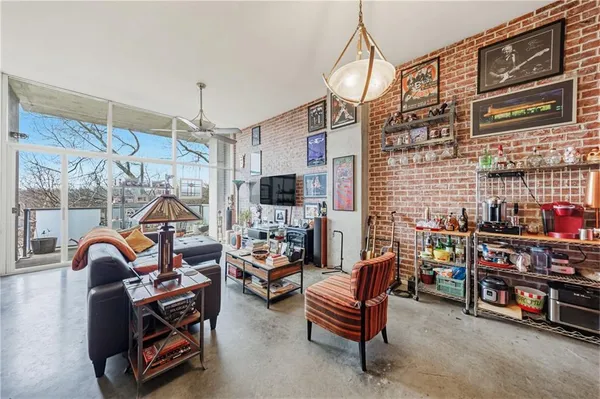 a living room with furniture a flat screen tv and a chandelier