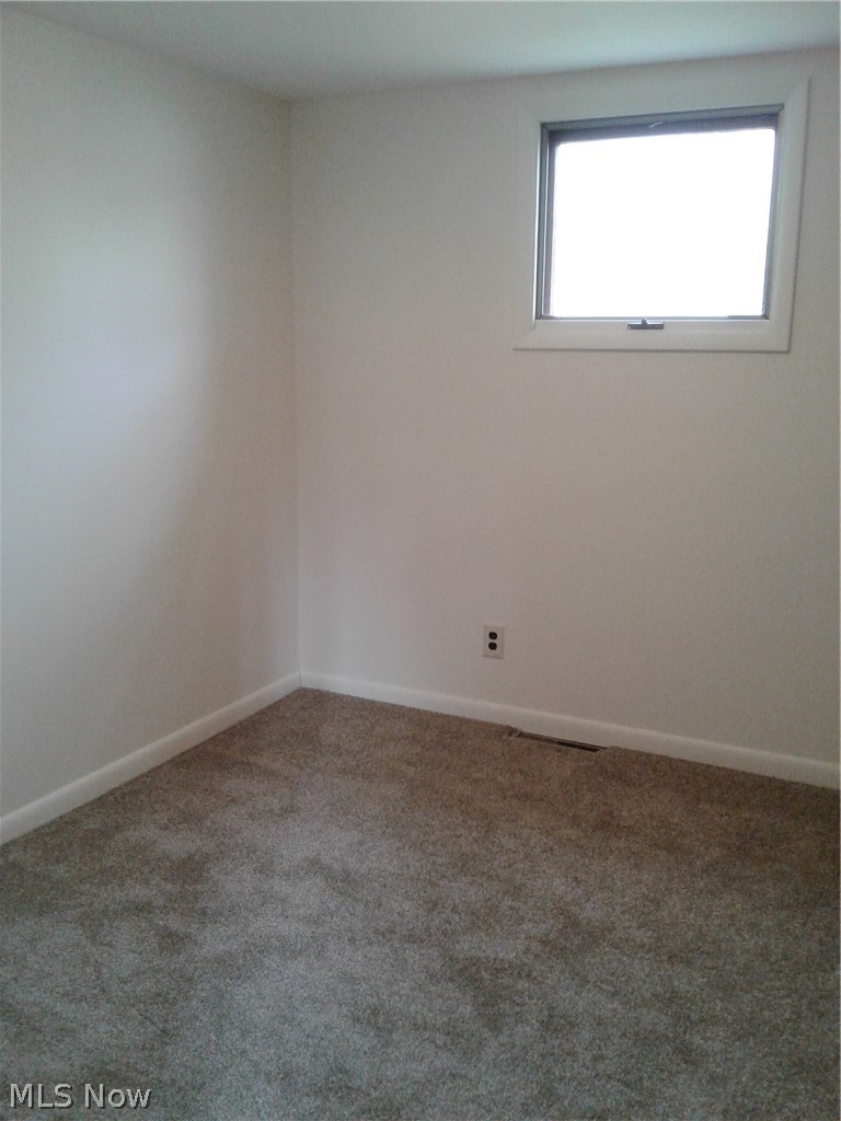 613 Jackson Street Amherst, OH 44001 - Photo 17 of 29 Carpeted spare room featuring baseboards and new carpet