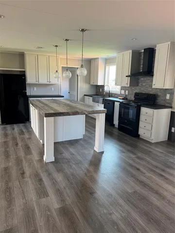 a kitchen with a refrigerator a sink and wooden floor