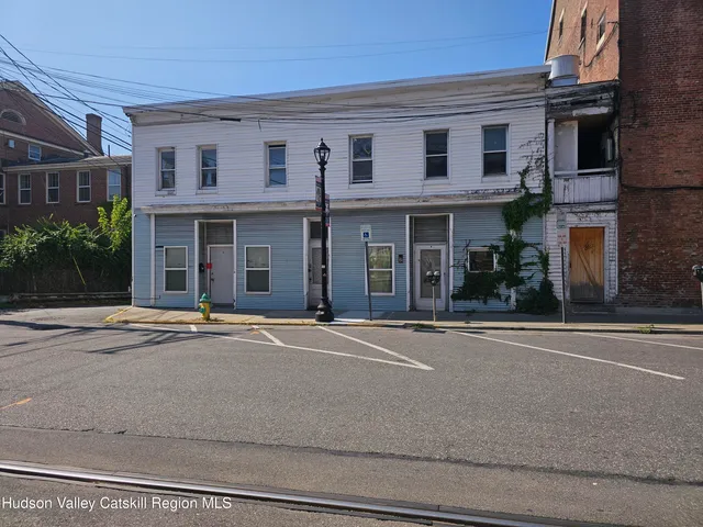 front view of a brick house with a yard
