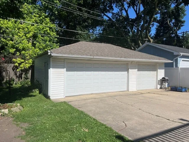 a backyard of a house with garage and trees