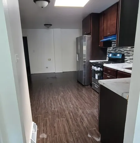 a kitchen with granite countertop a refrigerator stove and sink