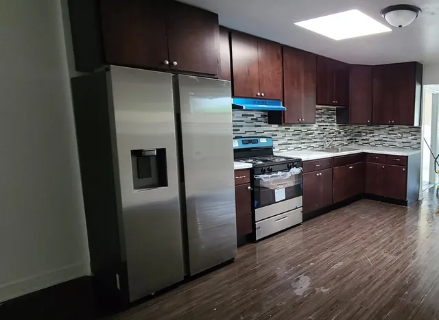 a kitchen with stainless steel appliances granite countertop a refrigerator and a stove