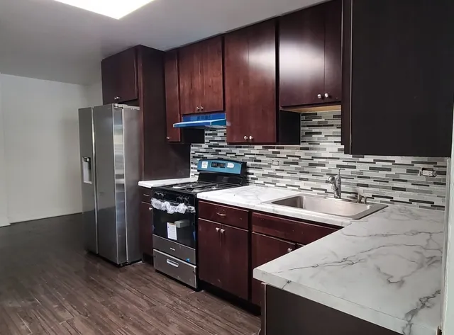 a kitchen with stainless steel appliances granite countertop a sink stove and refrigerator