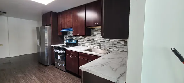 a kitchen with stainless steel appliances granite countertop a sink stove and refrigerator