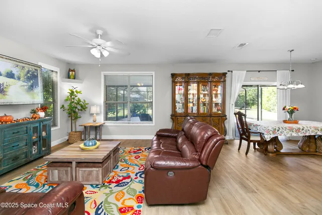 a living room with furniture and a floor to ceiling window
