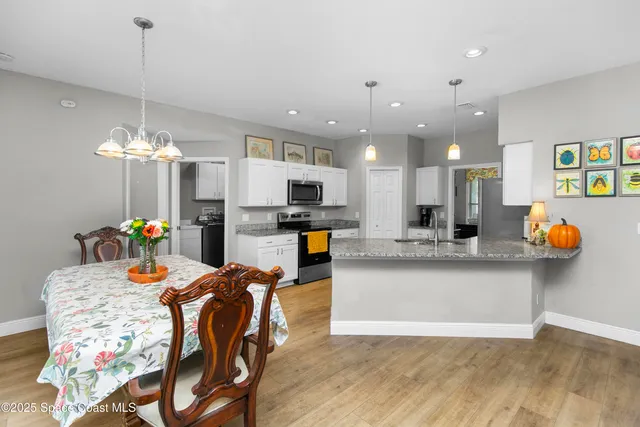 a view of a dining room and kitchen with furniture and wooden floor
