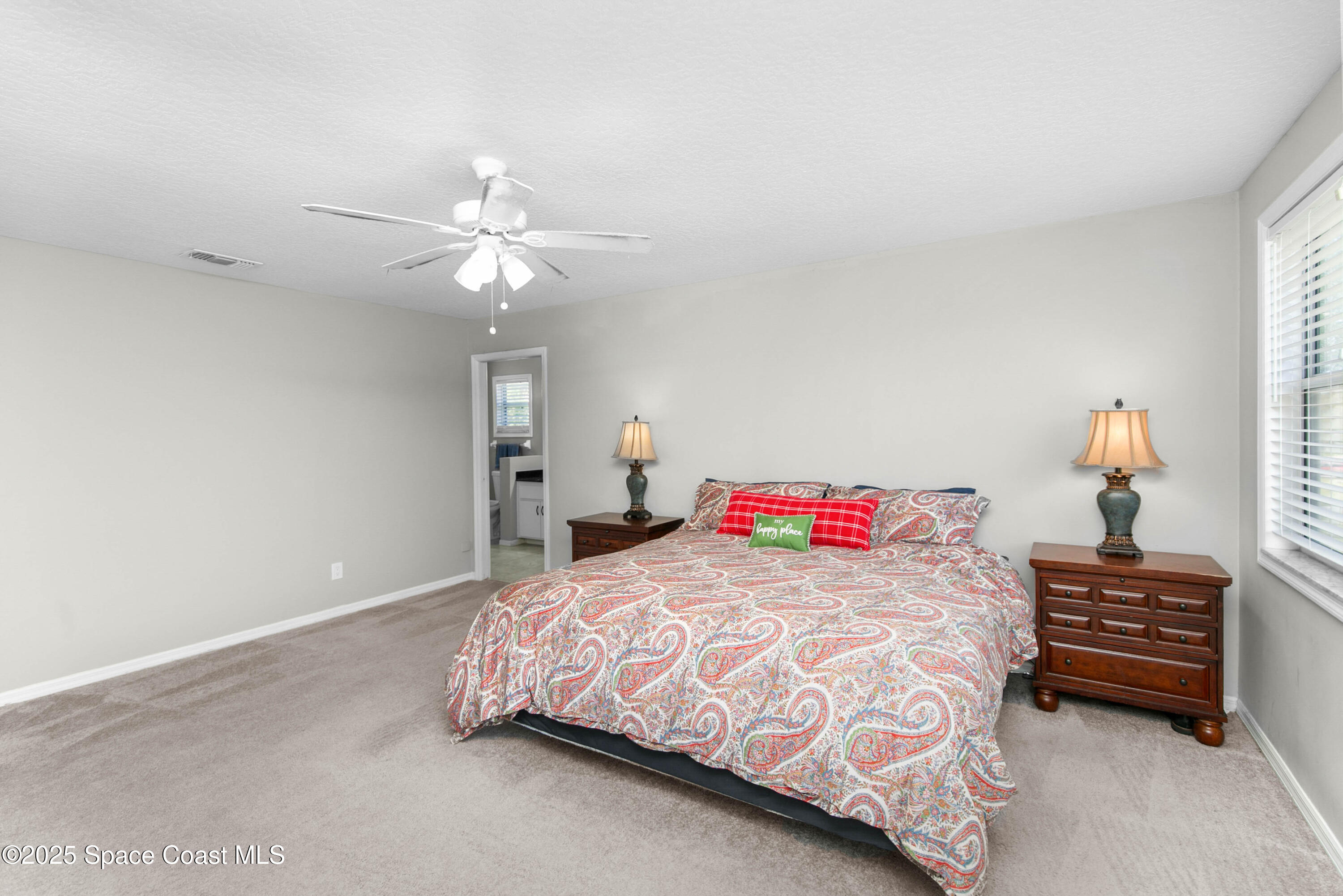3530 Big Pine Road Melbourne, FL 32934 - Photo 18 of 39 a bedroom with a bed and a chandelier fan