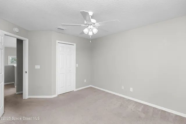 an empty room with a ceiling fan and a window
