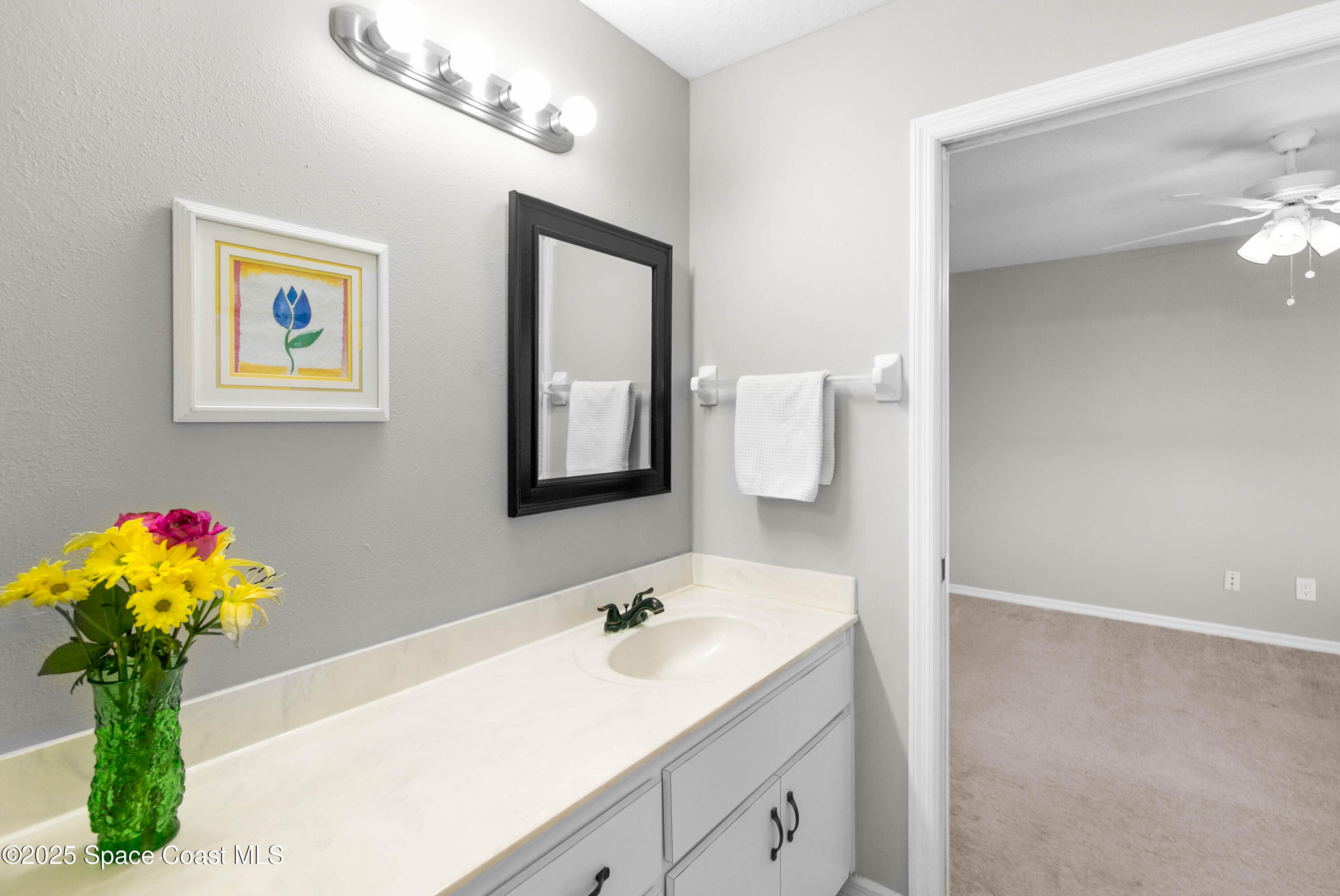 3530 Big Pine Road Melbourne, FL 32934 - Photo 26 of 39 a bathroom with a sink a large mirror and vanity