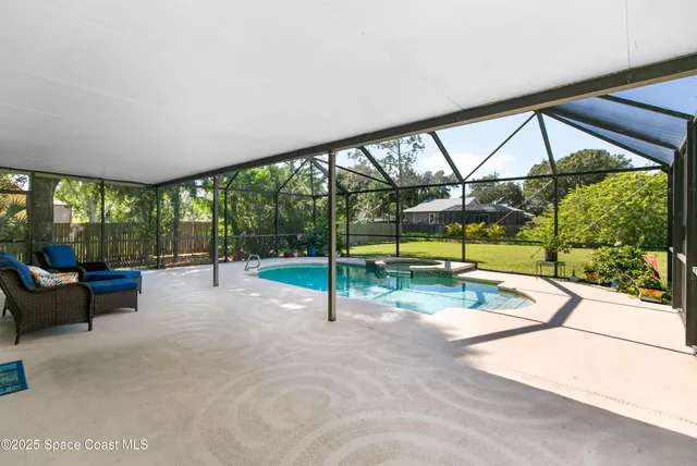 a view of a swimming pool with a patio and a backyard