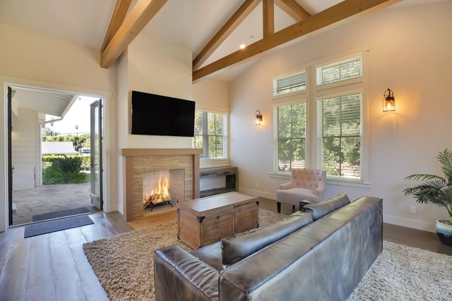 a living room with furniture a fireplace and a flat screen tv