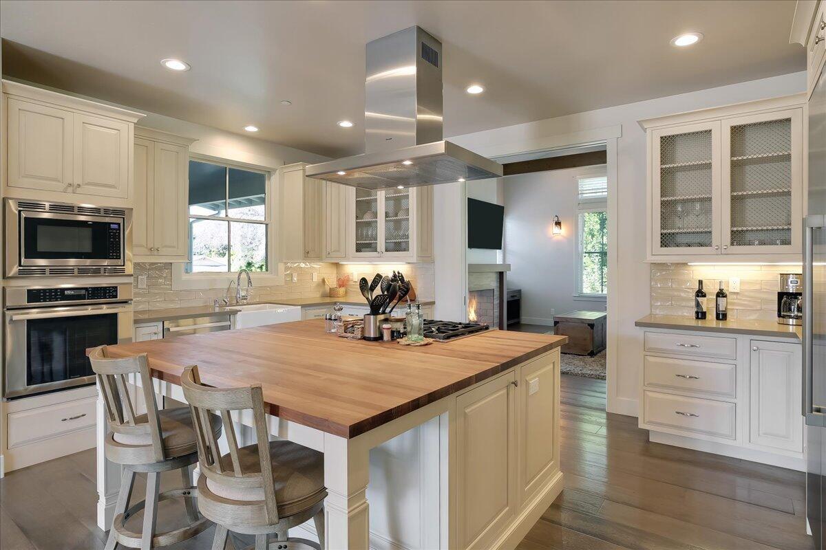 1030 Cambridge Drive Santa Barbara, CA 93111 - Photo 9 of 35 a kitchen with a stove a kitchen island with white cabinets and wooden floor