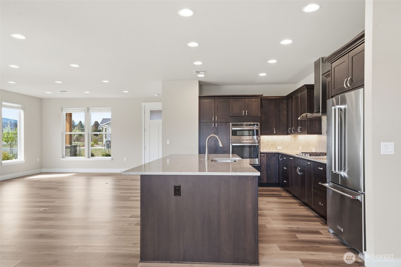 35 Viking Way Sequim, WA 98382 - Photo 14 of 39 a large kitchen with stainless steel appliances kitchen island granite countertop a large refrigerator a sink dishwasher and a stove with wooden floor