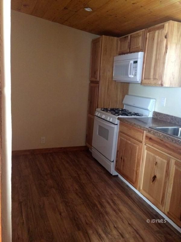 52810 Pine Cove Road Idyllwild, CA 92549 - Photo 17 of 21 a kitchen with granite countertop a stove top oven sink and cabinets