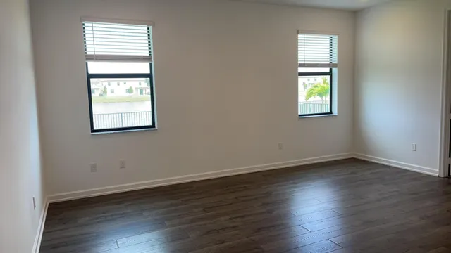 an empty room with wooden floor and a window