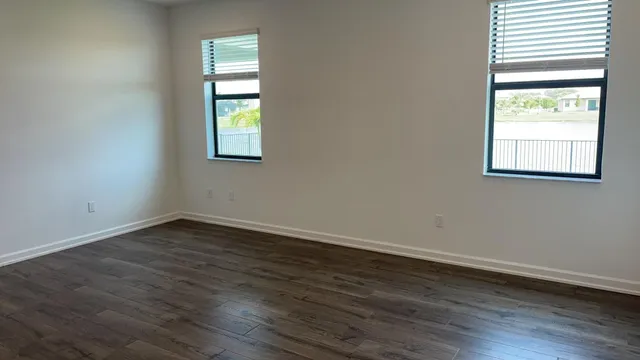 an empty room with wooden floor and window