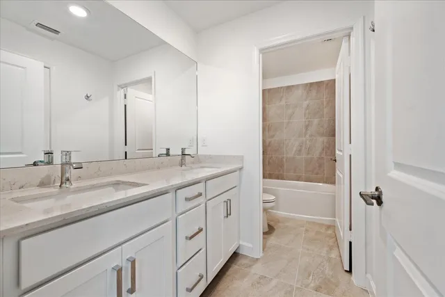 a bathroom with a granite countertop sink mirror and a bathtub