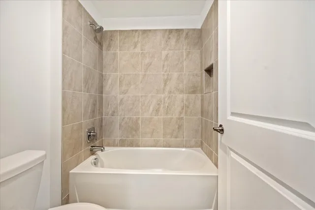 a bath tub sitting next to a white toilet and a sink